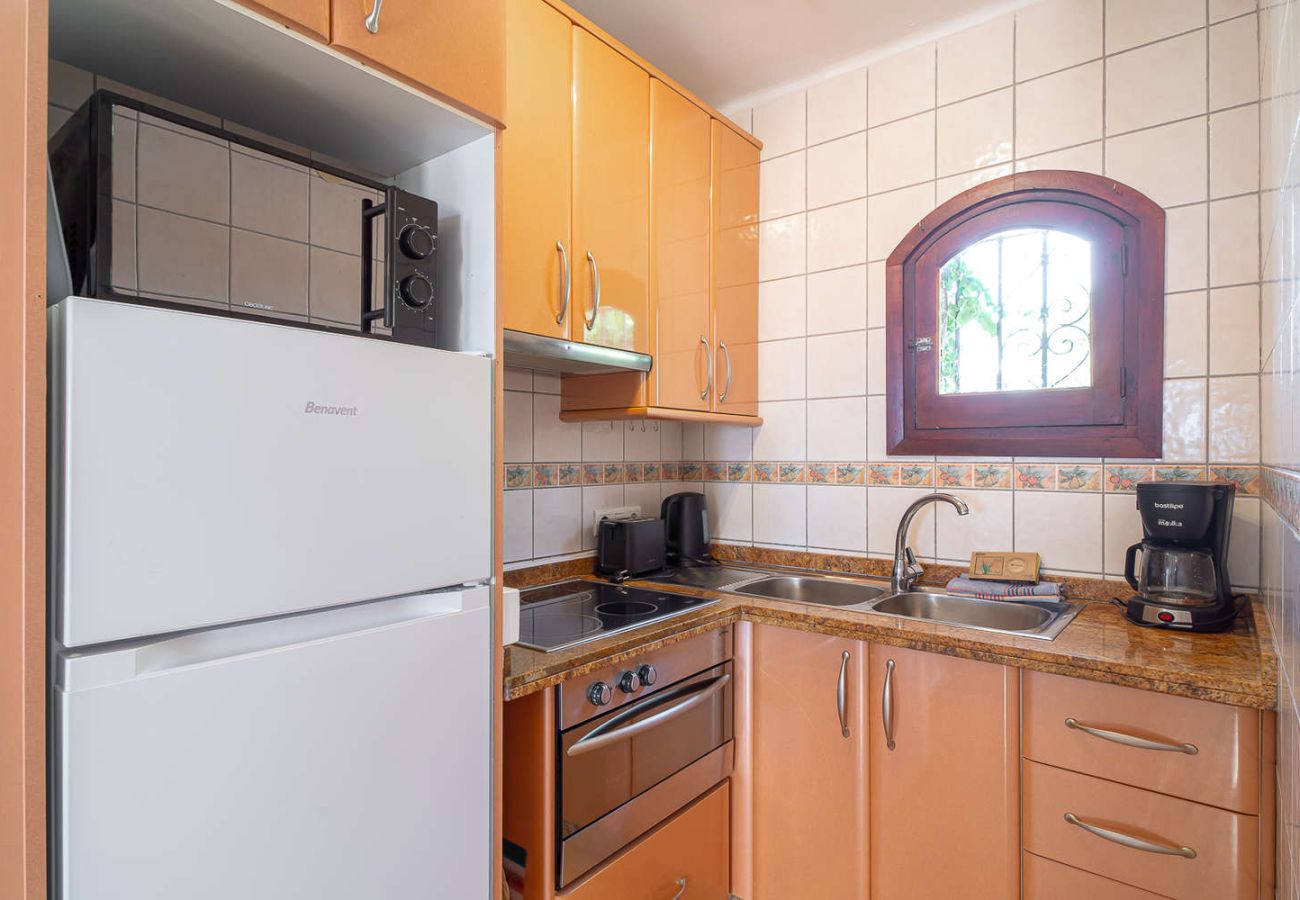 Cucina a vista completamente attrezzata con forno, microonde ed elettrodomestici.