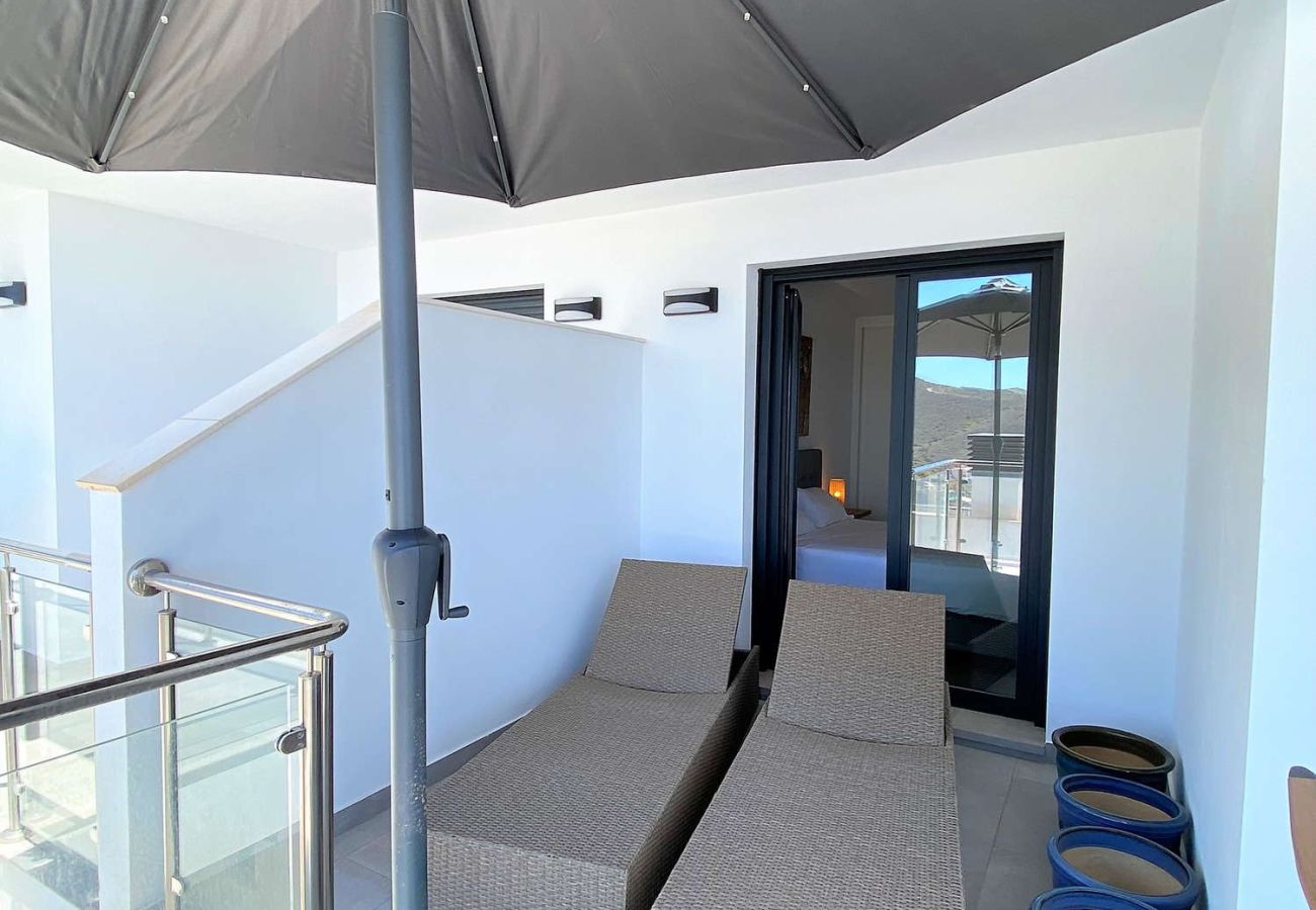 Area solarium privata con lettini e vista mare nell'appartamento 216.