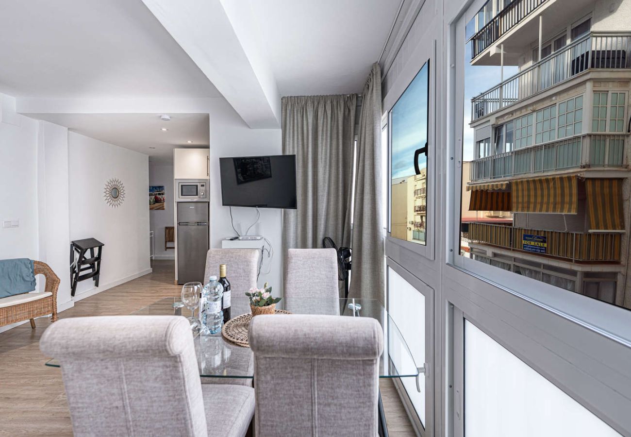 Zona pranzo con tavolo in vetro accanto a una grande finestra luminosa a Nerja.