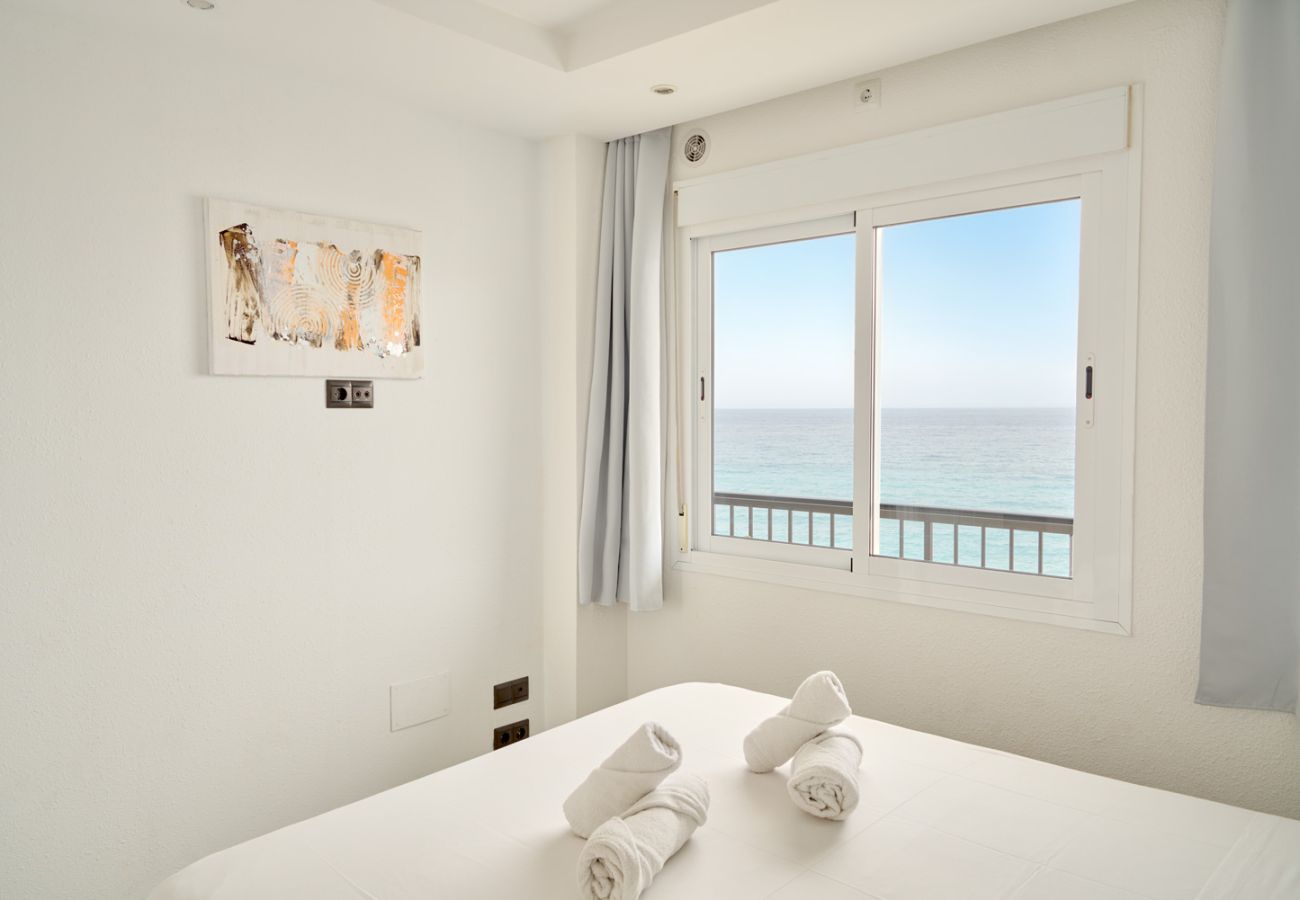 Camera da letto principale con letto matrimoniale e vista mare frontale dalla finestra.