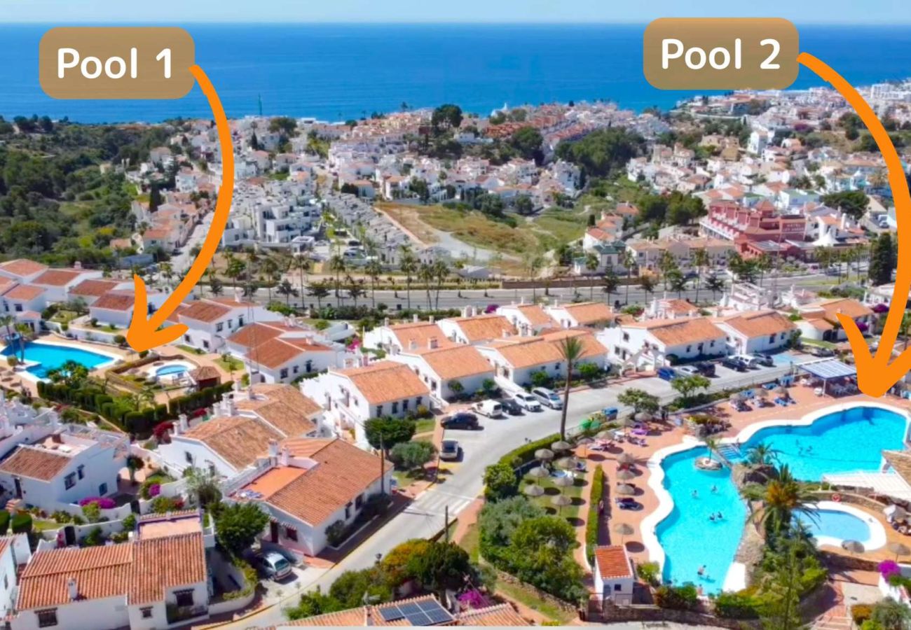 Vista aerea di Capistrano Village Nerja che mostra le case bianche e le due piscine comunitarie.