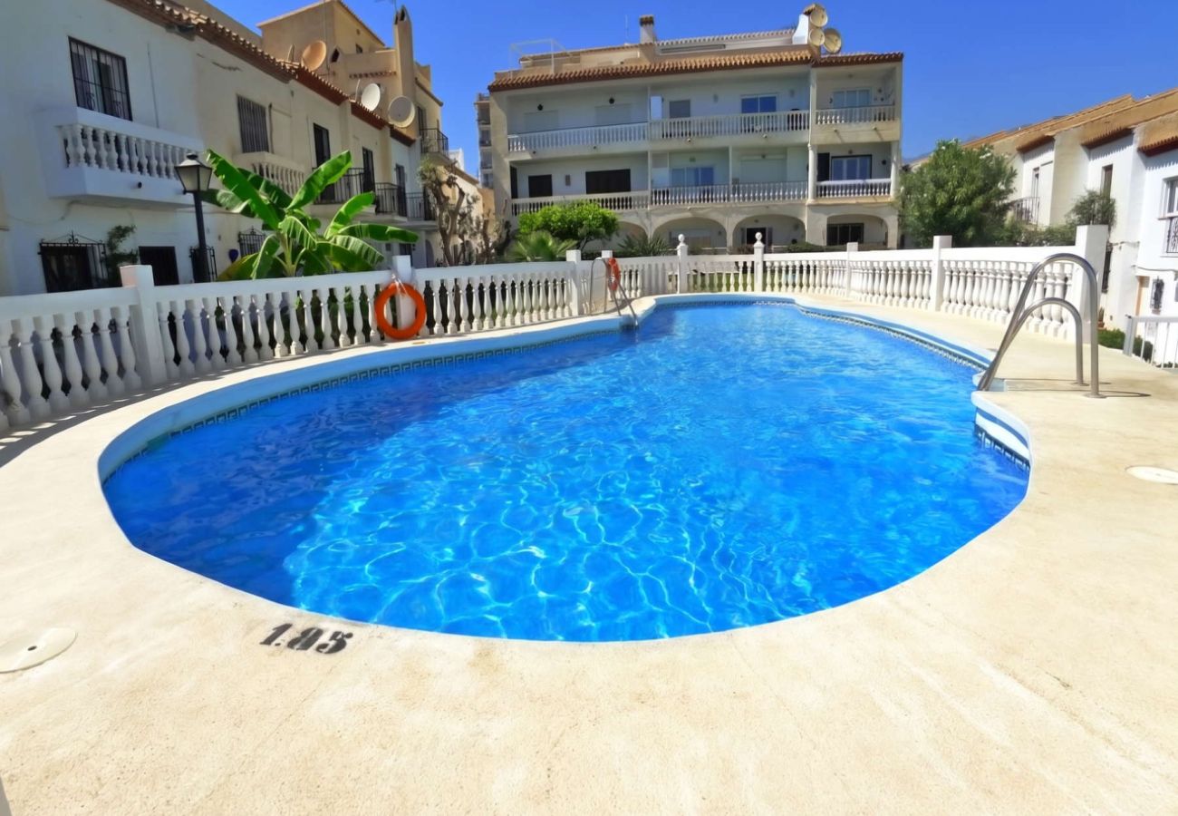 Piscina condominiale circondata da giardini nell'urbanizzazione La Hacienda, Nerja.