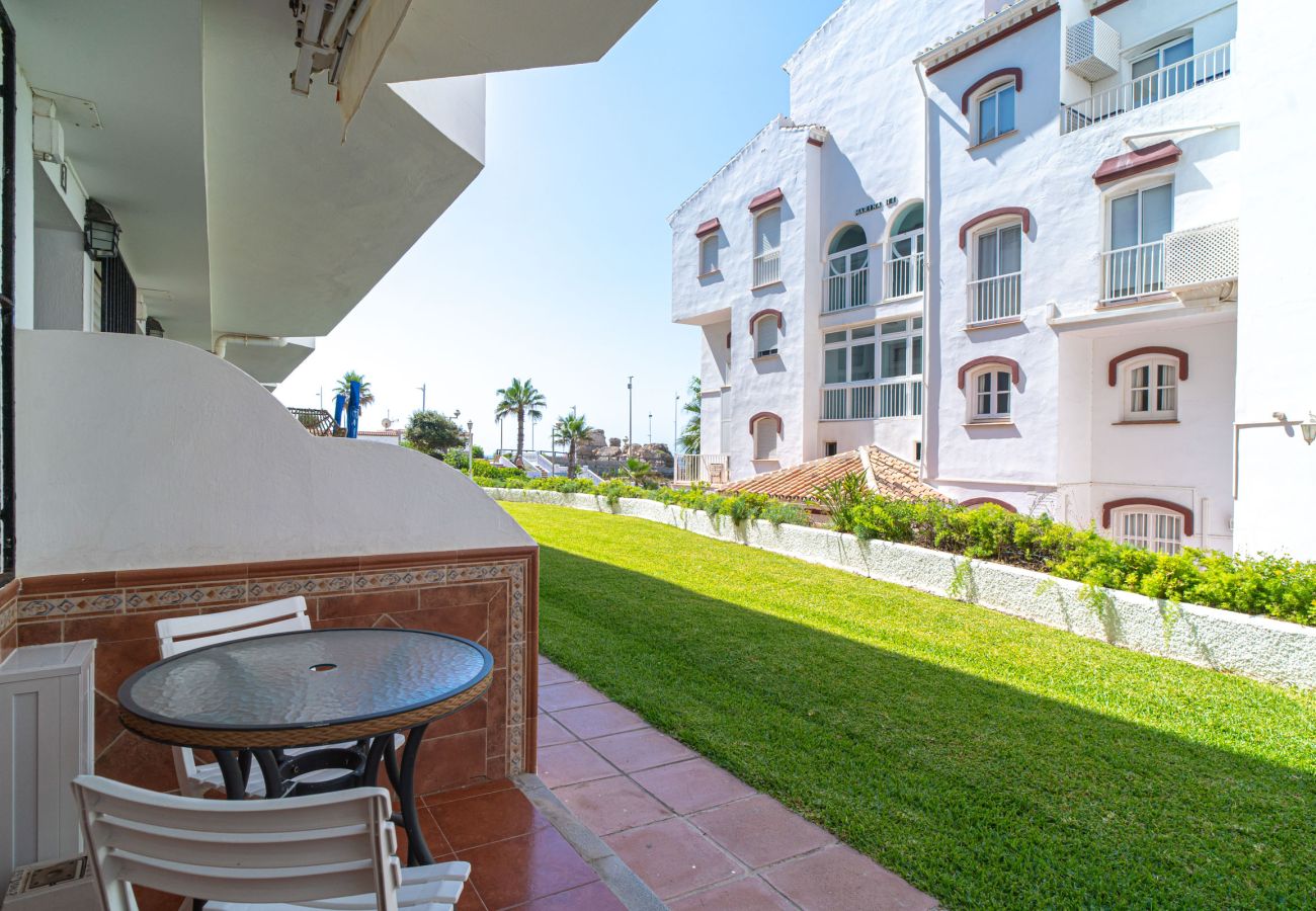 Terrazza d'ingresso dell'appartamento Arce 2 con tavolo e sedie di fronte al giardino condominiale.